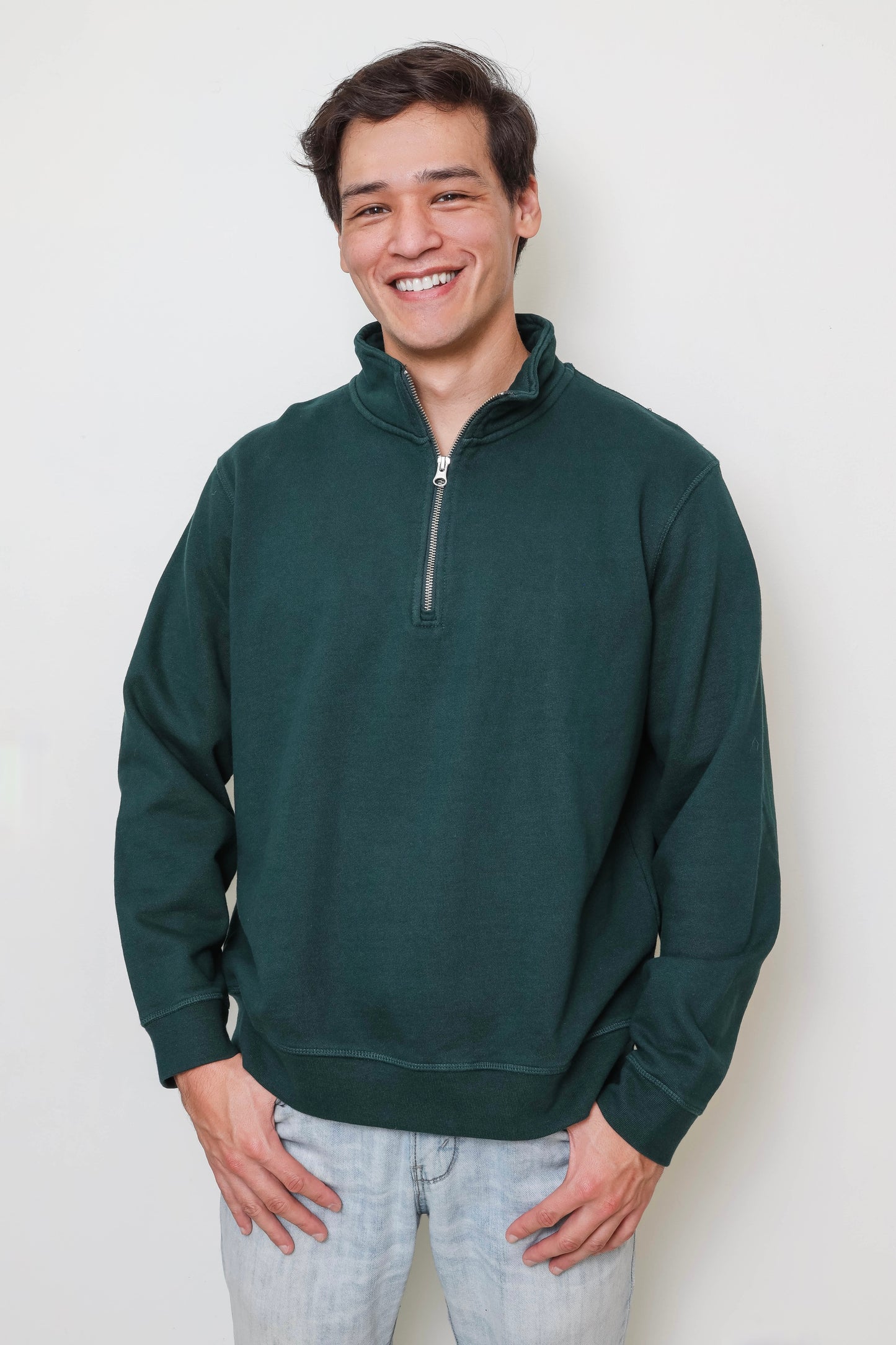 Man wearing a dark green pullover against a white background
